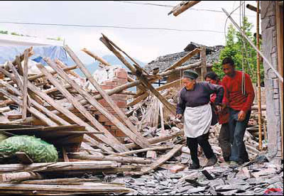 Villagers survey the remains of their houses in Wuxing. Isolation smashed as rescuers build lifeline