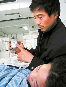 The father of a patient holds a bottle of clindamycin phosphate glucose at the No 2 Hospital Affiliated to Harbin Medical University on Thursday night.