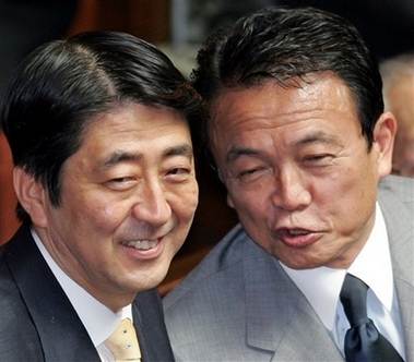 Japanese Prime Minister Shinzo Abe, left, chats with Foreign Minister Taro Aso prior to the opening of a Parliament session in Tokyo Thursday, Sept. 28, 2006. Abe, the new outspoken nationalist prime minister, is soaring in public opinion polls with support ratings for his Cabinet as high as 71 percent, according to surveys released Thursday by four major newspapers. (AP