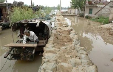 An elderly woman feeds her ducks on a boat, which is her temporary home after the village was flooded, in Fengyang County, east China's Anhui province July 21, 2007.