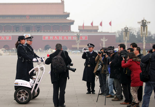 Two police officers riding two-wheeled patrol scooters became the focus of the media after the opening ceremony of the fifth session of the 11th CPPCC National Committee in Beijing. Perfect smiles for the perfect picture