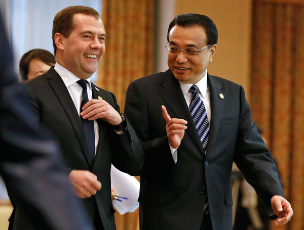Premier Li Keqiang talks with his Russian counterpart Dmitry Medvedev before the 12th prime ministers' meeting of the Shanghai Cooperation Organization in the Uzbek capital of Tashkent.  Reforms will expand trade ties with Russia: Premier
