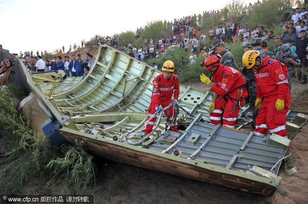 A debris searching team cleans the cowling of Shenzhou-X fell in Yulin, June 11, 2013.  Cowling of Shenzhou-X found in NW China