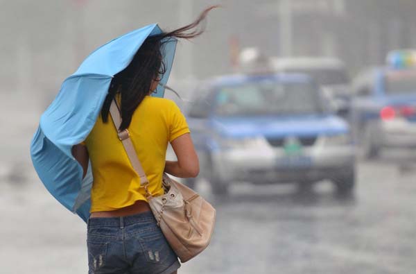 A woman braves the rain as typhoon Nesat approaches in Sanya, Hainan province, Sept 29, 2011.  300,000 evacuated as typhoon Nesat lands