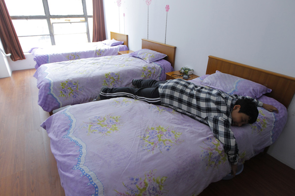 Xue Hongtian rests on his bed before going to school. Gao Erqiang / China Daily  Cast adrift, 12-year-old has to find new home
