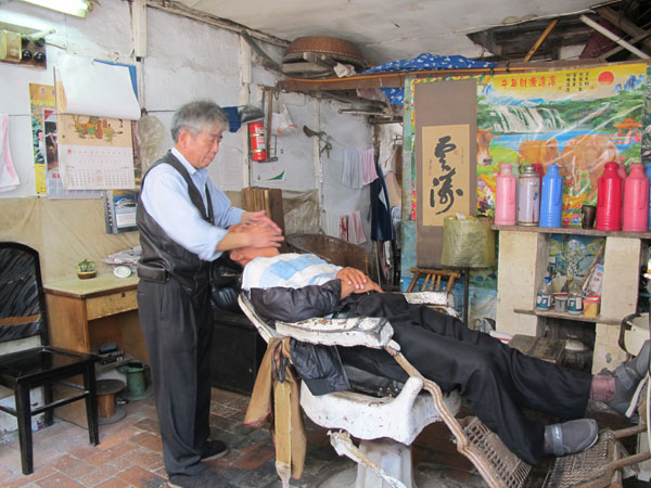 A traditional shave in the ancient town. Xu Xiaomin / China Daily  Relief from the madding crowds