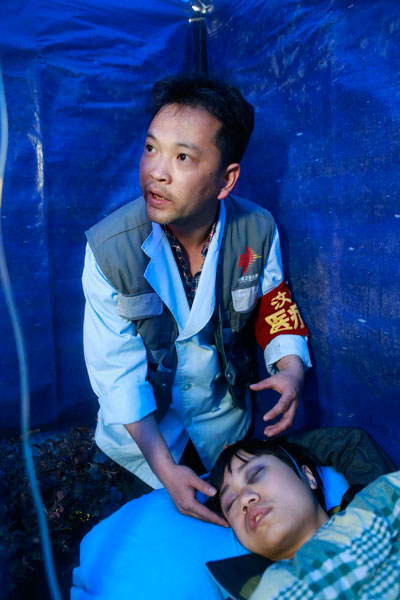Shen Yongkang, 34, a doctor at People's Hospital of Wenchuan County, Sichuan province, treats a patient injured in the earthquake in Lushan county. FENG YONGBIN / CHINA DAILY Medical personnel provide assistance with little rest