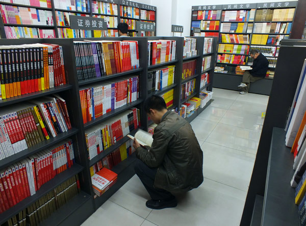 People read at a book store in Yichang, Central China's Hubei province, April 23, 2013. E-books pose challenges to traditional reading