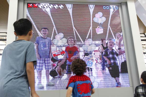 Children play an interactive LED game in the departure lounge at Shanghai Pudong International Airport's Terminal 2. Lu Haitao / for China Daily Games help time fly for young held-up passengers