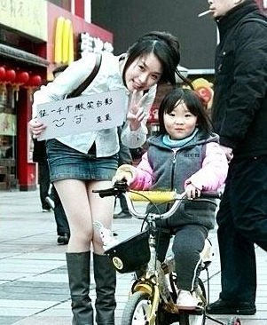 美女在南京街頭舉牌征集1000個(gè)微笑合影