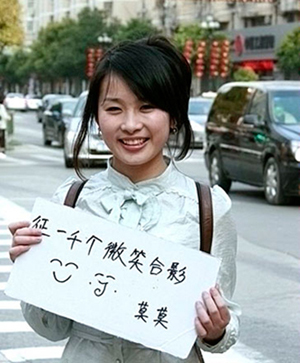 美女在南京街頭舉牌征集1000個(gè)微笑合影