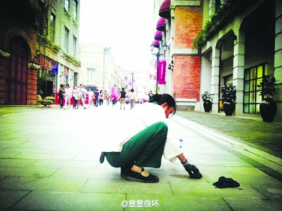 清潔工蹲地鏟口香糖照片走紅 網(wǎng)友呼吁尊重勞動(dòng)（圖）