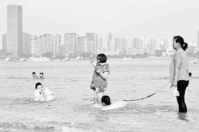 家長漢江中牽著繩子“遛小孩”無視岸邊警示標牌(圖)