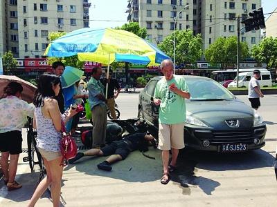騎車男被卷入轎車輪下 路人抬起轎車救人（圖）