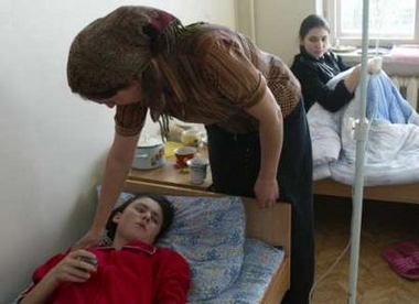 A relative takes care of a Chechen girl in hospital of Grozny, December 21, 2005.