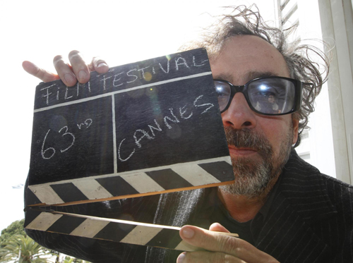 Tim Burton holds a film clapper in Cannes