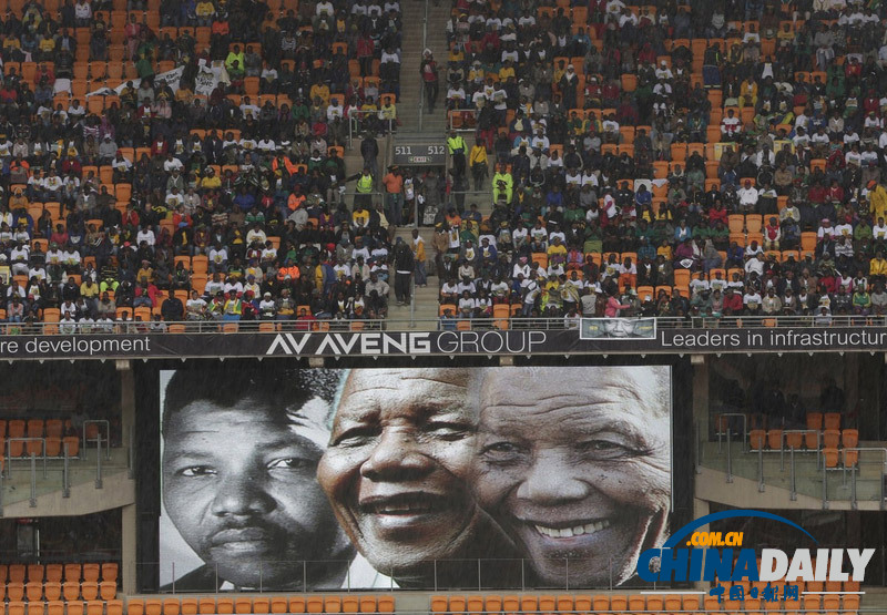 曼德拉追悼會(huì)現(xiàn)場(chǎng):情侶為偉人海報(bào)打傘