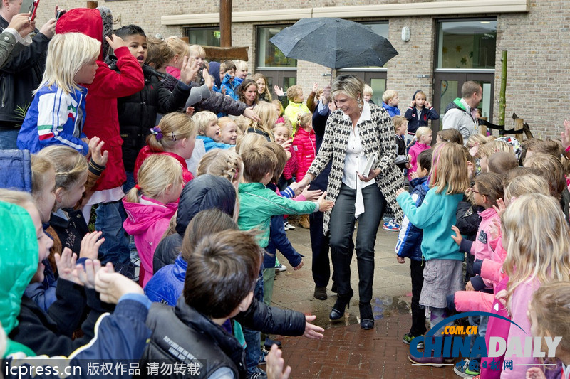 荷蘭王妃探訪學(xué)校專(zhuān)人撐傘 孩子們站立雨中迎接（組圖）