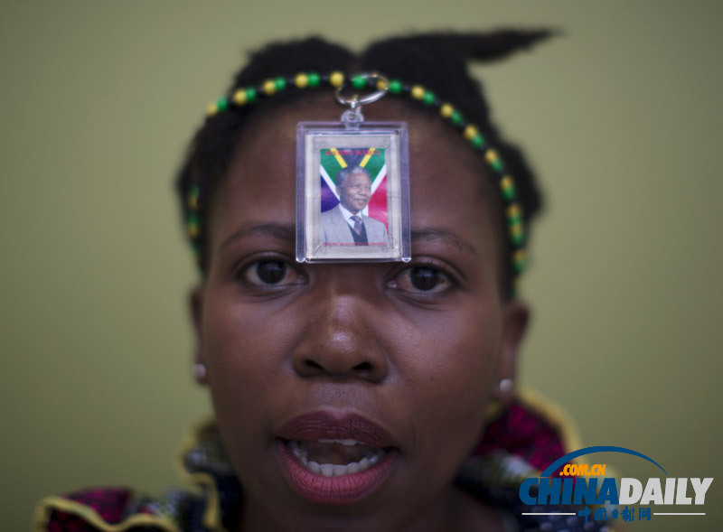 曼德拉追悼會現(xiàn)場：情侶為偉人海報(bào)打傘