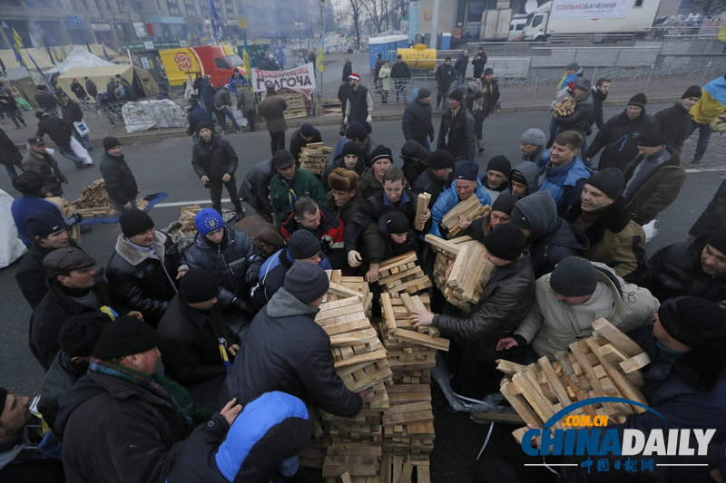 烏克蘭示威者收集柴火擬長(zhǎng)期抗?fàn)? valign=