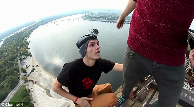 極限運(yùn)動(dòng)愛好者握住同伴手腕懸掛115米高空