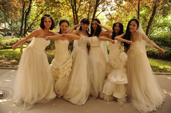 College graduates from LCU pose for graduation photos in Liaocheng, East China's Shandong province, June 1, 2013.  Graduates in wedding gowns honor college years