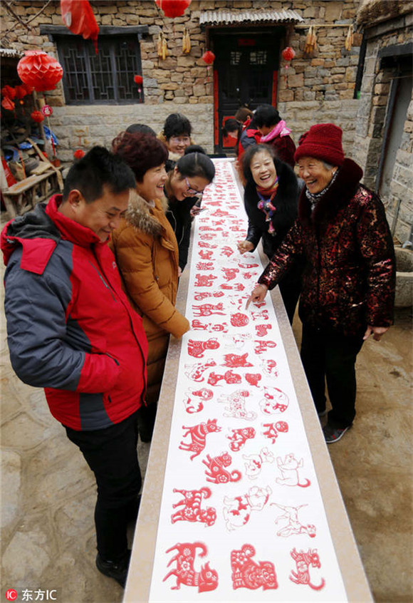 Folk artist creates long scroll of dog-themed paper-cuts