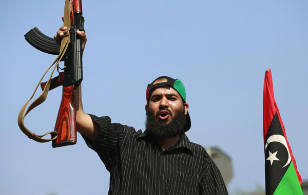 A Libyan rebel fighter celebrates as they drive through Tripoli's Qarqarsh district August 22, 2011. Rebels seize Tripoli, inch toward victory