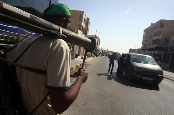 Libyan rebel fighters search vehicles at a checkpoint in Tripoli's Qarqarsh district August 22, 2011. Rebels seize Tripoli, inch toward victory