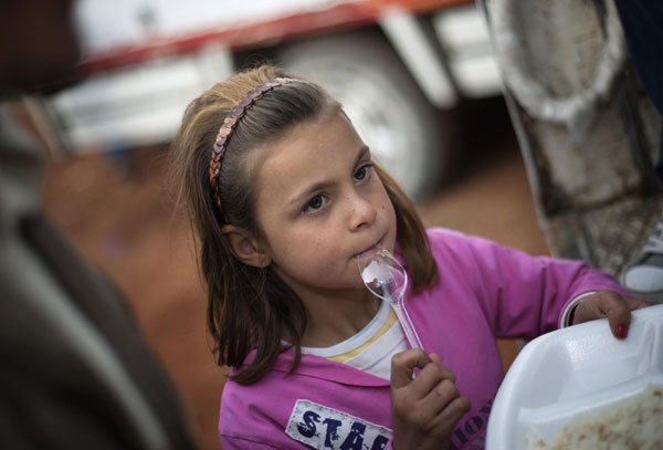 A girl waits for her meal to be distributed at a stadium which is used as a relief shelter campsite for earthquake victims in Ercis Oct 26, 2011. Turkey struggles to shelter people after quake
