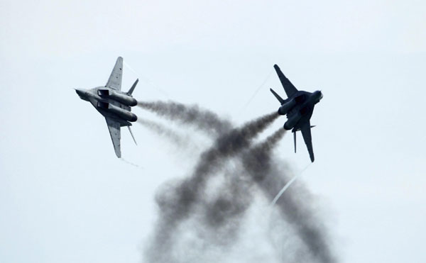 Royal Malaysian Air Force (RMAF) Smokey Bandits aerobatic display team, in their MiG-29N 'Fulcrum' fighter aircrafts, performs a cross during an aerial display at the Singapore Airshow in Singapore February 16, 2012. Singapore holds largest airshow in Aisa