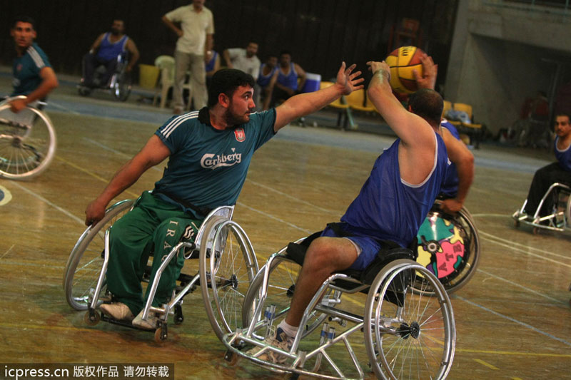 Kirkuk team player Abbas Mohammed (L) tries to block a pass against Nassiriyah team player Jassim Jaber during their match at the Shaab indoor arena in central Baghdad, on July 30, 2009. Public sports in post-war Iraq