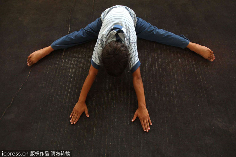 An Iraqi child stretches on a mat at a gymnasium on the outskirts of the southern city of Karbala, some 110 kms from Baghdad, on July 12, 2009. Public sports in post-war Iraq