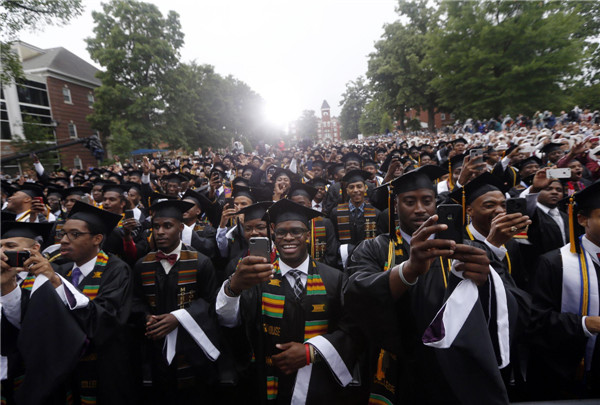 Members of the graduating class of 2013 take pictures as US President Barack Obama arrives on stage for the graduation ceremony at Morehouse College in Atlanta, Georgia, May 19, 2013. Obama delivers Morehouse commencement