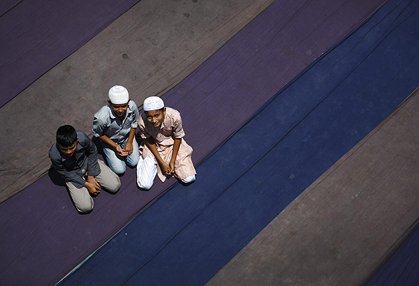 Nepalese Muslim boys wait to offer Friday prayers during the Muslim holy month of Ramadan in Kathmandu July 12, 2013. Muslim offer Friday prayers during Ramadan