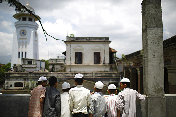 Nepalese Muslim men look out from the windows of a mosque as they wait to offer Friday prayers during the Muslim holy month of Ramadan in Kathmandu July 12, 2013. Muslim offer Friday prayers during Ramadan