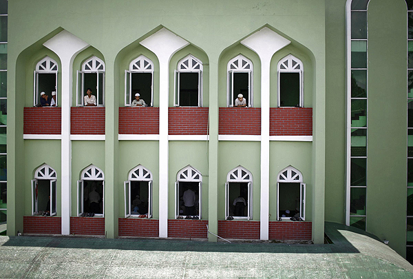 Nepalese Muslim men look out from the windows of a mosque as they wait to offer Friday prayers during the Muslim holy month of Ramadan in Kathmandu July 12, 2013. Muslim offer Friday prayers during Ramadan