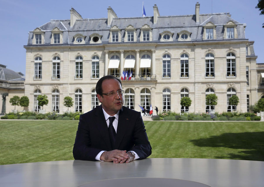French President Francois Hollande speaks with journalists after a television interview in the garden of the Elysee Palace following the traditional Bastille day military parade in Paris July 14, 2013. France celebrates Bastille Day