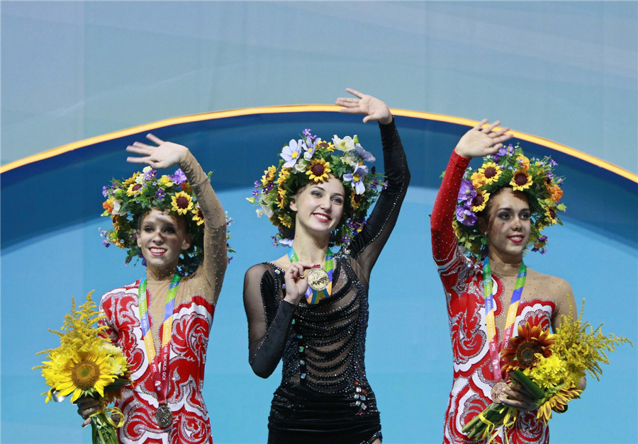 Gold medallist Ganna Rizatdinova of Ukraine (C), silver medallist Yana Kudryavtseva (L) of Russia and bronze medallist Margarita Mamun of Russia wave to fans during the award ceremony after the individual hoop competition final at the 32nd Rhythmic Gymnastics World Championships in Kiev, Aug 28, 2013. Moments from 32nd rhythmic gymnastics worlds