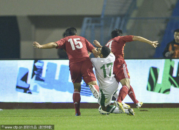 China's Xu Bo, left, and Zhao Xuri, right, defend against a Saudi Arabian player during their 2015 AFC Asian Cup qualifiers in Dammam, Saudi Arabia, Feb 6, 2013.  China defeated by Saudi Arabia 2-1 at Asian Cup qualifiers