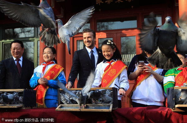 David Beckham, center, sets free doves with local students during his visit to the former residence of Soong Ching-ling in Beijing, on March 24, 2013, as his five-day China visit came to an end. Beckham catches up with Chinese culture on last stop