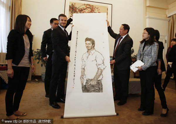David Beckham, third left, receives a portrait of himself as a gift during his visit to the former residence of Soong Ching-ling in Beijing, on March 24, 2013, as his five-day China visit came to an end. Beckham catches up with Chinese culture on last stop