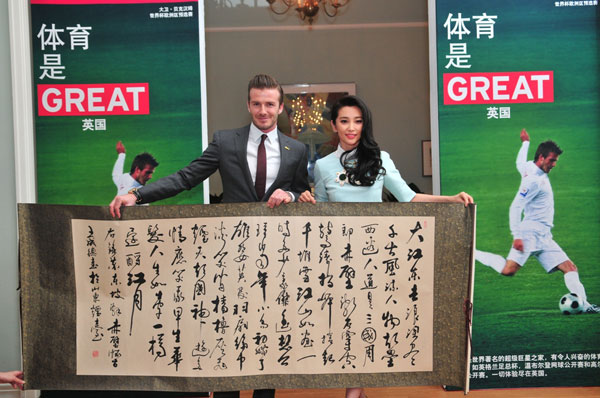 David Beckham displays a piece of Chinese calligraphy with China-UK Cultural Exchange Ambassador Li Bingbing, right, during his visit to the UK embassy to China in Beijing, on March 24, 2013, as his five-day China visit came to an end. Beckham catches up with Chinese culture on last stop