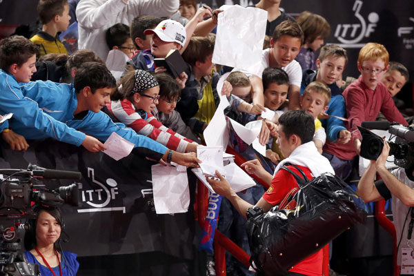 China's Xu Xin signs autographs after his victory over Steffen Mengel of Germany in their men's singles opening round at the World Team Table Tennis Championships in Paris, May 15, 2013. Top seed Xu Xin reaches second round in Paris tournament