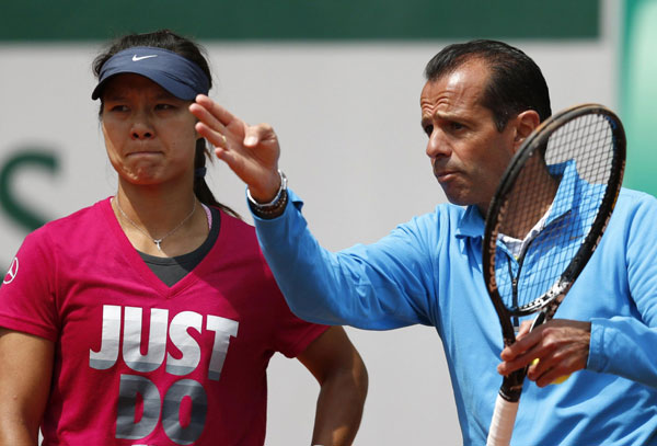 China's Li Na listens to her coach Carlos Rodriguez during a training session for the French Open tennis tournament at the Roland Garros stadium in Paris, May 25, 2013. Li Na in preparation for French Open
