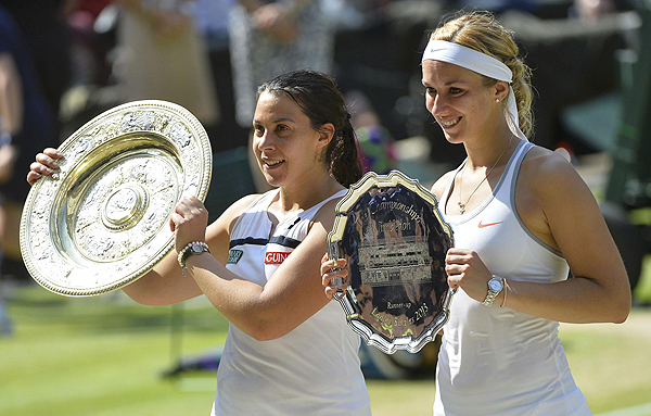 Marion Bartoli of France (L) holds her trophy, the Venus Rosewater Dish, after defeating Sabine Lisicki of Germany (R) in their women's singles final tennis match at the Wimbledon Tennis Championships, in London on July 6, 2013. Bartoli sinks tearful Lisicki to win Wimbledon