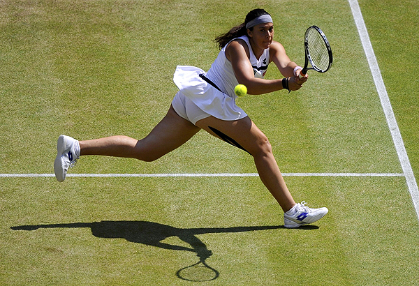 Marion Bartoli of France hits a return to Sabine Lisicki of Germany during their women's singles final tennis match at the Wimbledon Tennis Championships, in London on July 6, 2013. Bartoli sinks tearful Lisicki to win Wimbledon