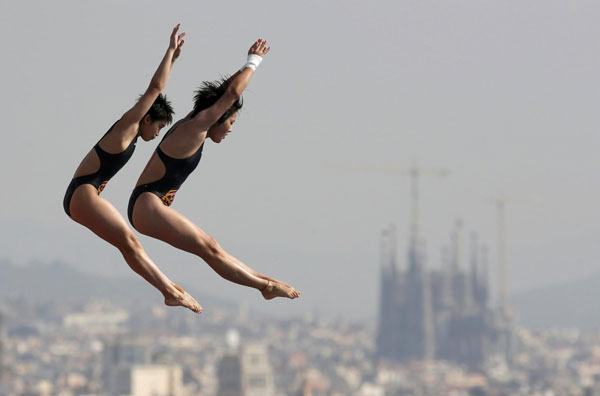 China's Liu Huixia, left, and Chen Ruolin perform a dive at the women's synchronised 10m platform preliminary during the World Swimming Championships at the Montjuic municipal pool in Barcelona, July 22, 2013. China wins one more gold at World Championships