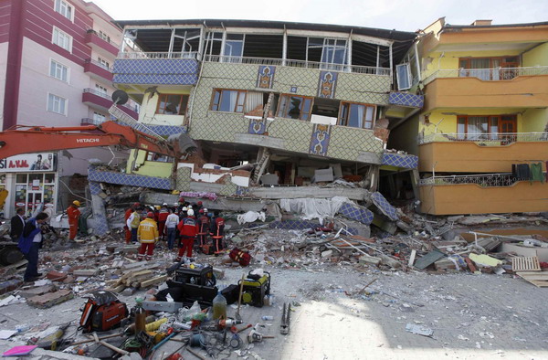 Rescue workers try to save people trapped under debris after an earthquake in Ercis, near the eastern Turkish city of Van, October 24, 2011.  Turkey quake death toll exceeds 260