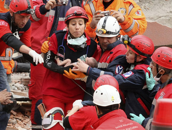 Rescue workers carry a baby from a collapsed building in Ercis, near the eastern Turkish city of Van, October 25, 2011.  Baby rescued 2 days after Turkey quake